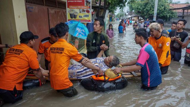 Sejumlah relawan mengevakuasi warga yang sakit di lokasi terdampak banjir, di Pekalongan, Jawa Tengah, Minggu (27/1/2019).  (Foto: ANTARA FOTO/Harviyan Perdana Putra)