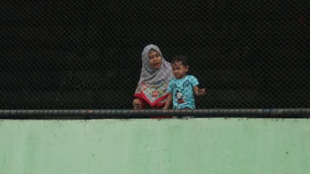 Seorang ibu dan anaknya di Pasar Grogol, Jakarta Barat, Minggu, (27/1).   (Foto: Jamal Ramadhan/kumparan)