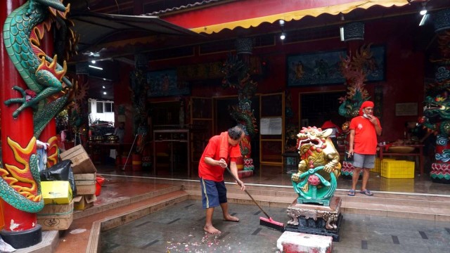 Sejumlah warga bergotong royong membersihkan Vihara Amurva Bhumi di kawasan Karet Kuningan, Jakarta, Senin (28/1).  (Foto: Irfan Adi Saputra/kumparan )