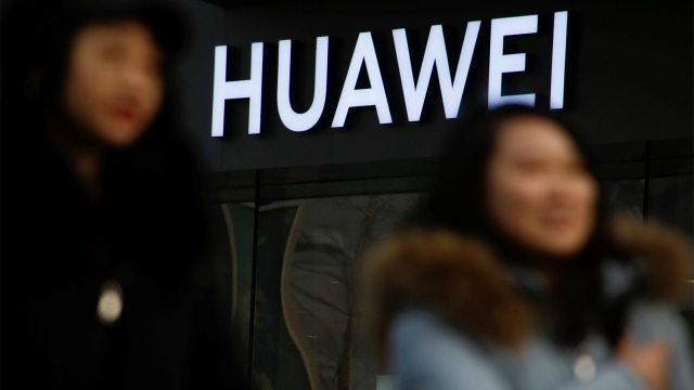 Sejumlah pengunjung melintasi toko Huawei. Foto: REUTERS/Thomas Peter