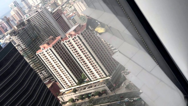 Masyarakat melihat Aksi Alain Robert yang dikenal sebagai "The French Spiderman", dari dalam Menara Internasional GT berlantai 43 di Makati City, Metro Manila, Filipina. (Foto: Marcus Aliwalas via REUTERS)
