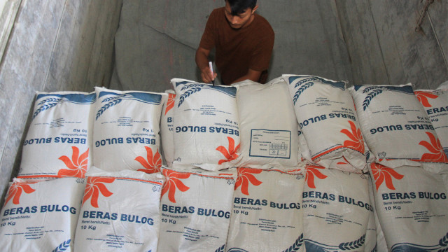Pekerja mendata jumlah karung beras untuk Rakyat Sejahtera (Rastra) di gudang Perum Bulog Subdivisi Regional. Foto: ANTARA FOTO/Syifa Yulinnas