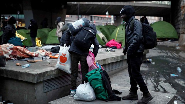 Para imigran mengambil barang-barang mereka ketika polisi Prancis mengevakuasi ratusan imigran yang tinggal di bawah jembatan Porte de la Chapelle, Paris, Prancis (29/1/2019). (Foto: REUTERS/Benoit Tessier)