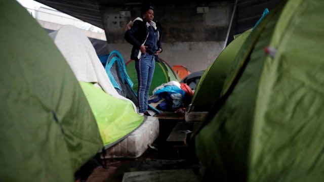 Seorang imigran perempuan bersiap untuk meninggalkan kamp sementara yang berada di bawah jembatan Porte de la Chapelle, Paris, Prancis (29/1/2019). (Foto: REUTERS/Benoit Tessier)