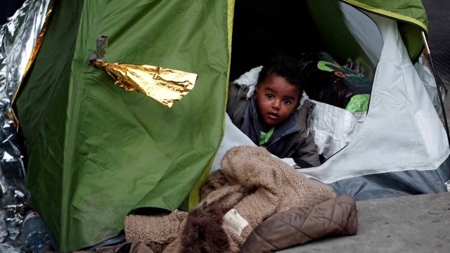 Seorang anak laki-laki tinggal di kamp sementara yang berada di bawah jembatan Porte de la Chapelle, Paris, Prancis (29/1/2019). (Foto: REUTERS/Benoit Tessier)