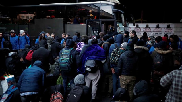 Para imigran beranjak untuk menaiki bus setelah dievakuasi oleh polisi Prancis di bawah jembatan Porte de la Chapelle, Paris, Prancis (29/1/2019). (Foto: REUTERS/Benoit Tessier)