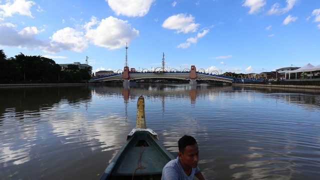 Pengunjung bisa menaiki perahu kayu untuk berkeliling di sungai Cisadane dan berfoto dengan latar belakang jembatan Berendeng di Tangerang. (Foto: Dimas)