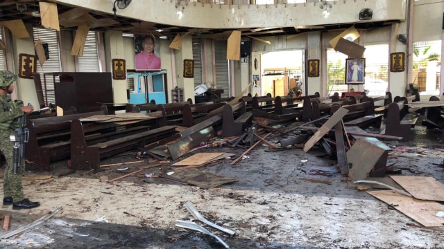 Seorang anggota Angkatan Darat Filipina memeriksa kerusakan di dalam Gereja usai ledakan bom di Jolo, Provinsi Sulu, Filipina. Foto: Reuters