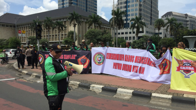 Sejumlah Ojek online bentangkan spanduk saat aksi di Bundaran Patung Kuda, Jakarta Pusat, Minggu (3/2). Foto: Fachrul Irwinsyah/kumparan
