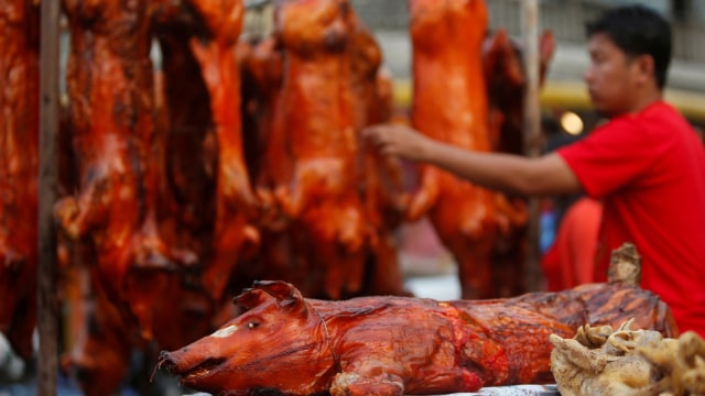 Seorang pria membeli babi panggang menjelang Tahun Baru Imlek di Phnom Penh, Kamboja, (4/2). Foto: REUTERS/Samrang Pring
