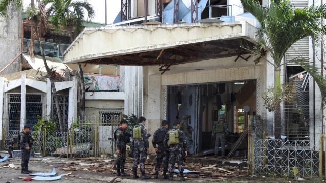 Petugas keamanan Filipina berjaga usai ledakan di sebuah gereja di Jolo, provinsi Sulu di Pulau Mindanao Selatan, (27/12019). Foto: AFP/NICKEE BUTLANGAN