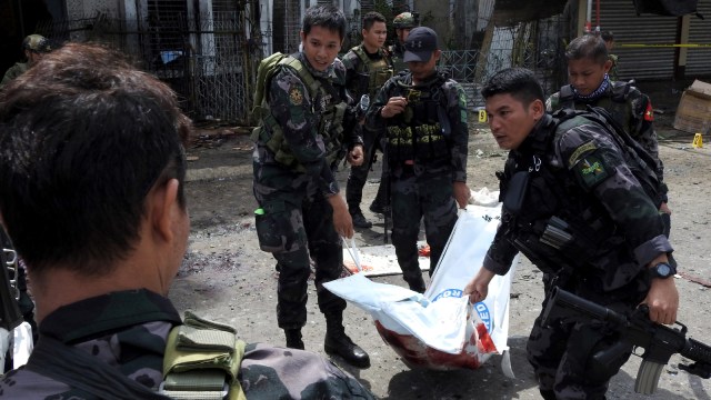 Petugas keamanan Filipina membawa kantung jenazah berisi korban ledakan di sebuah gereja di Jolo, provinsi Sulu di Pulau Mindanao Selatan, (27/12019). Foto: AFP/NICKEE BUTLANGAN