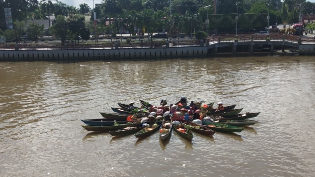Acil jukung pasar terapung menampilkan atraksi formasi bintang di Siring Sungai Martapura, Jalan Pierre Tendean, Banjarmasin pada Rabu (6/2/2019). Foto: Zahidi/banjarhits.id