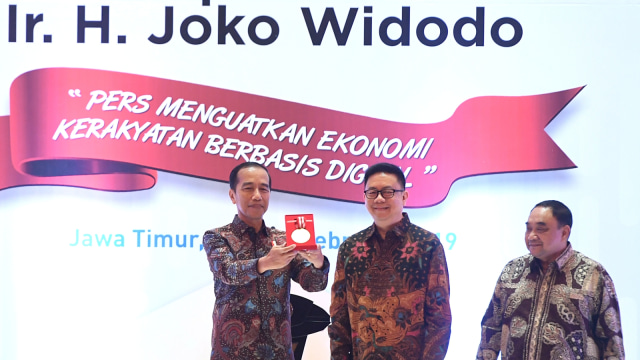 Presiden Joko Widodo (kiri) menunjukan medali kemerdekaan pers saat puncak perayaan Hari Pers Nasional (HPN) di Surabaya, Jawa Timur, Sabtu (9/2/2019). Foto: ANTARA FOTO/Zabur Karuru