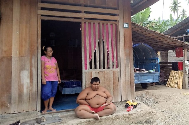 Aslam bocah penderita obesitas, merupakan warga Desa Mantangisi, Kecamatan Ampana Tete, Kabupaten Tojo Una Una (Touna), Sulawesi Tengah. Keseharian Aslam menghabiskan waktu bersandar, duduk dan tidur. (Foto: Situr Wijaya)