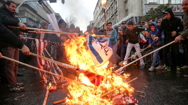 Sejumlah warga Iran membakar bendera Amerika Serikat dalam peringatan Hari Revolusi Islam di Iran. Foto: Kantor Berita Meghdad Madadi/Tasnim/melalui REUTERS