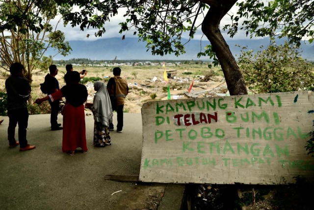 Potret warga berdiri menatap Desa Petobo, Palu, yang 'tertelan' Bumi setelah bencana lukuefaksi, Senin (11/2). Foto: Suparta/acehkini
