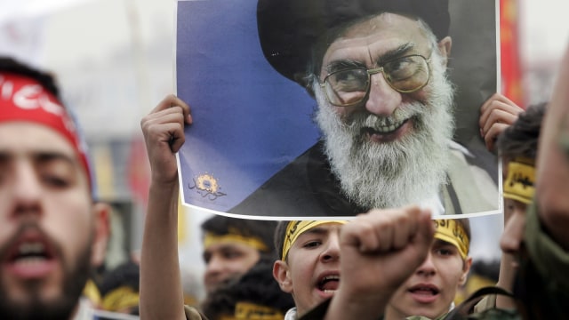 Masyarakat membawa poster bergambar Ayatullah Khomeini. Foto: Shutter stock