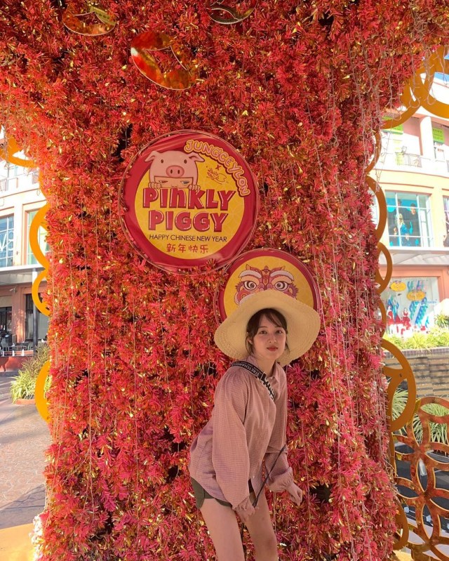 Kim Bora berpose di depan instalasi serba merah dengan tulisan Pinkly Piggy. Foto: Instagram @kim_bora95