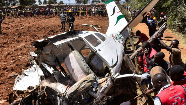 Sejumlah tim penyelamat berusaha mengevakuasi pesawat Cessna 206 yang jatuh di Londiani, Kericho, Kenya, (13/2). Foto: AFP/SULEIMAN MBATIAH