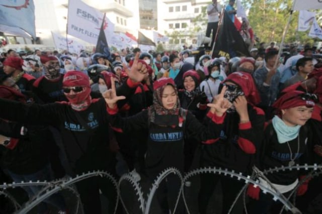 Buruh terlihat mengacungkan salam dua jari saat menggelar aksi demo tuntuk penandatanganan SK UMSK (Foto:Johanes Saragih/Batamnews)