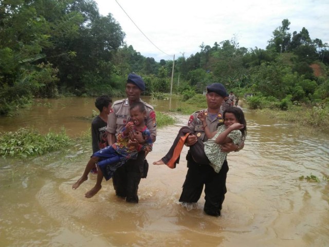 Personel Brimob Polda Sulbar mengevakuasi anak-anak yang terdampak banjir di Desa Sejati Tobadak 8, Kecamatan Tobadak, Kabupaten Mamuju Tengah, Sulawesi Barat, Kamis (14/2). (Foto: Dok Humas Polda Sulbar)