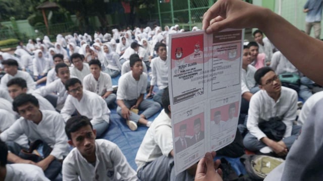 Relawan Demokrasi KPU Kota Jakarta Pusat menunjukan kertas surat suara kepada para siswa di SMAN 4 Jakarta, Jumat (15/2). Foto: Irfan Adi Saputra/kumparan