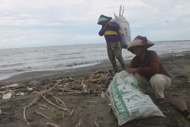 Sejumlah pekerja tengah membersihkan material sampah di Pantai Karangsong Kecamatan Indramayu Kabupaten Indramayu,beberapa waktu lalu.Setiap harinya pekerja pengangkut sampah di pantai Karangsong Kabupaten Indramayu Jawa Barat, membersihkan 1 ton material sampah.(tomi indra)