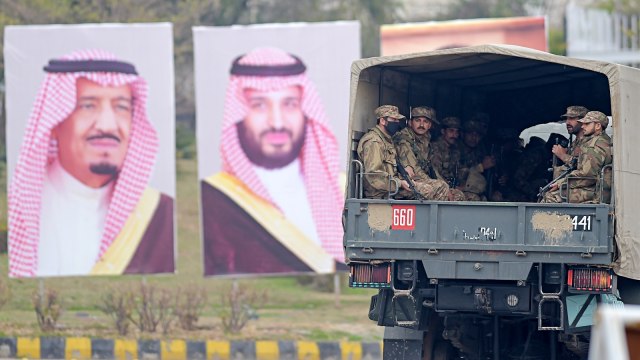 Tentara Pakistan sedang berpatroli di jalan melewati poster Putra Mahkota Arab Saudi Pangeran Mohammed bin Salman di Islamabad. Foto: AFP/AAMIR QURESHI