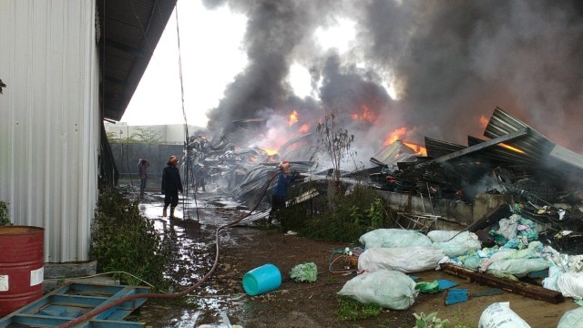 Sejumlah petugas pemadam kebakaran Gresik berusaha memadamkan api yang membakar gudang milik PT Blueshark di Gresik, Jawa Timur. Foto: Dok. Istimewa