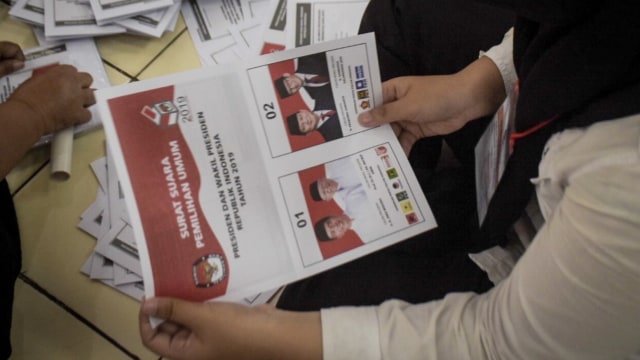 Sejumlah petugas melipat surat suara presiden dan wakil presiden Pemilu 2019 di kantor Komisi Pemilihan Umum (KPU) Jakarta Barat, Selasa (19/2). Foto: Iqbal Firdaus/kumparan
