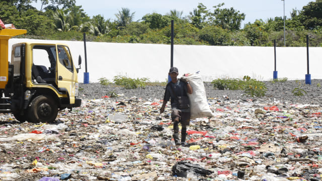 Seorang pemulung saat mengangkat sampah di lokasi TPA di Kelurahan Takome, Ternate, Maluku Utara. Foto: Layang Sutanto/cermat