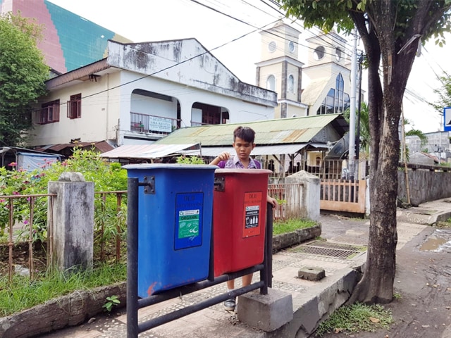 Seorang siswa SD di Kota Manado, membuang sampah botol plastik ke tempat sampah yang tersedia di jalan Samratulangi Manado