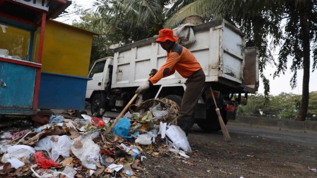 Petugas membersihkan sampah yang dibuang sembarangan oleh warga di salah satu kawasan dalam Kota Banda Aceh, Kamis (21/2). Foto: Suparta/acehkini 