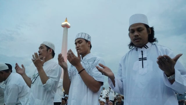Sejumlah peserta Malam Munajat 212 berdoa di Monumen Nasional (Monas), Jakarta, kamis, (21/2). Foto: Jamal Ramdhan/kumparan