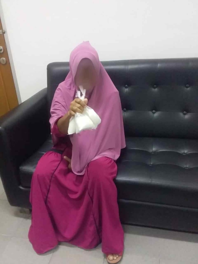 Pelaku bersama barang bukti yang diselundupkan di dalam pembalut yang dipakainya