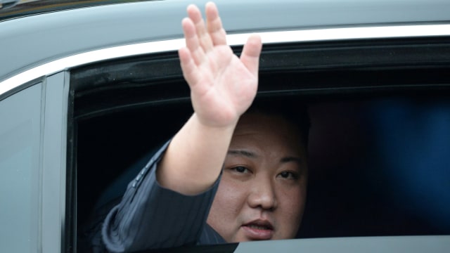 Pemimpin Korea Utara Kim Jong-un melambaikan tangan di dalam kendaraannya setelah tiba di stasiun kereta Dong Dang, Vietnam, Selasa (26/2). Foto: REUTERS/STR