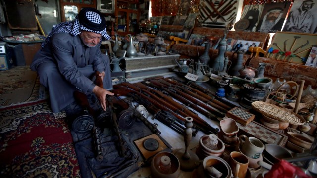 Youssef Akkar, menunjukan senapan koleksinya di museum pribadinya di Najaf, Irak. Foto: REUTERS/Alaa al-Marjani