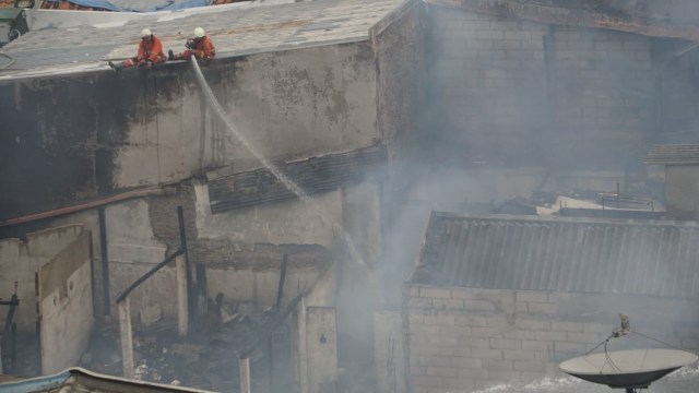 Petugas pemadam kebakaran lakukan pendinginan usai memadamkan api yang membakar rumah di Kelurahan Krukut, Kecamatan Tamansari, Jakarta Barat, Selasa, (26/2). Foto: Jamal Ramadhan/kumparan