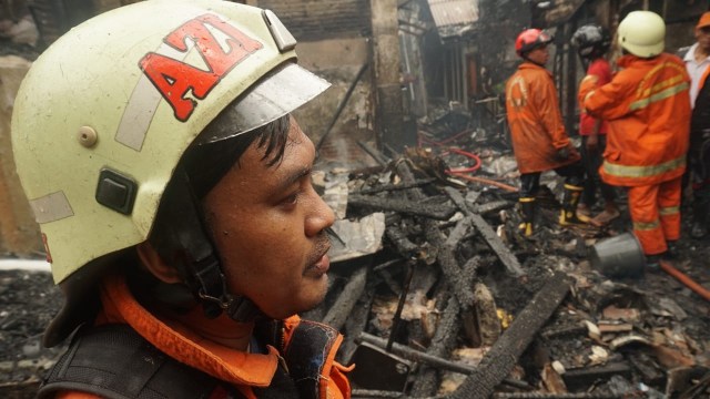 Petugas pemadam kebakaran lakukan pendinginan usai memadamkan api yang membakar rumah di Kelurahan Krukut, Kecamatan Tamansari, Jakarta Barat, Selasa, (26/2). Foto: Jamal Ramadhan/kumparan