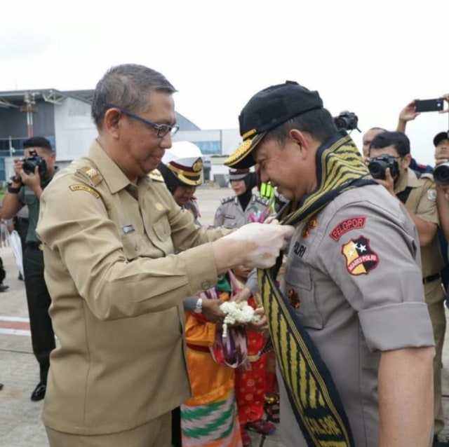 Gubernur Kalbar mengalungkan syal bermotif corak insang kepada Kapolri Jenderal Pol. Tito Karnavian saat tiba di bandara Supadio Pontianak, Selasa (26/2). Foto: Humas Polda Kalbar