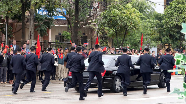 Para pengawal mengelilingi kendaraan Pemimpin Korea Utara, Kim Jong-un saat meninggalkan stasiun kereta api Dong Dang, Vietnam. Foto: Reuters