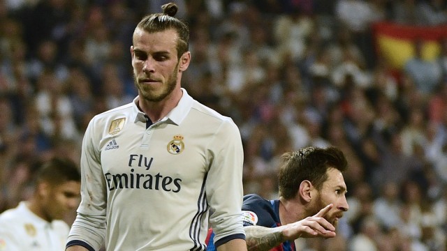 Gareth Bale menunjukkan ekspresi datar saat bintang Barcelona, Lionel Messi, merayakan gol ke gawang Real Madrid. Foto: Pierre-Philippe Marcou/AFP