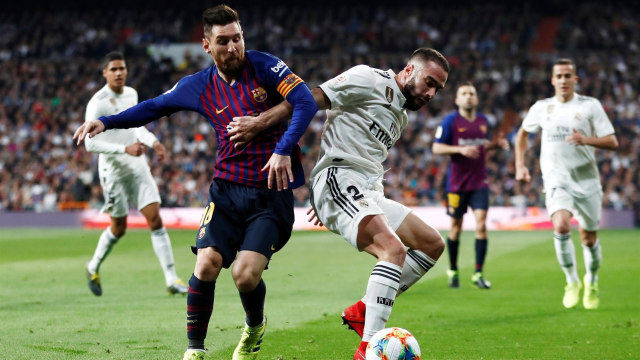 Duel Real Madrid vs Barcelona di Copa del Rey. Dani Carvajal (putih) berusaha keras mempertahankan bola dari Lionel Messi. Foto: Juan Medina/Reuters
