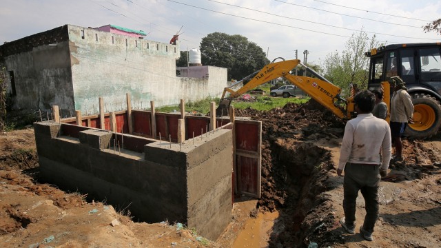 Pekerja membangun bungker beton di perumahan India dekat perbatasan Pakistan di sektor Samba, Jammu. Foto: REUTERS/Mukesh Gupta