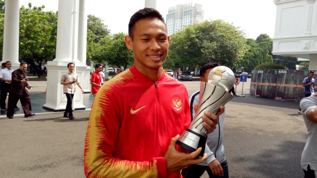 Pemain Timnas U-22 Dimas Drajad memegang piala AFF saat tiba di Kompleks Istana Kepresidenan, Kamis (28/2). Foto: Kevin Kurnianto/kumparan