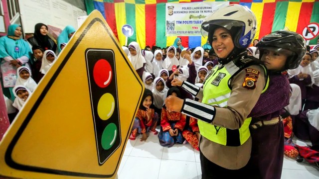 Petugas kepolisian Lalu Lintas Polres Lhokseumawe mengajarkan anak PAUD pemahaman rambu lalu lintas di Taman Kanak (TK) dan PAUD Nurul Iman, Lhokseumawe, Aceh, Kamis (28/2). Foto: ANTARA FOTO/Rahmad