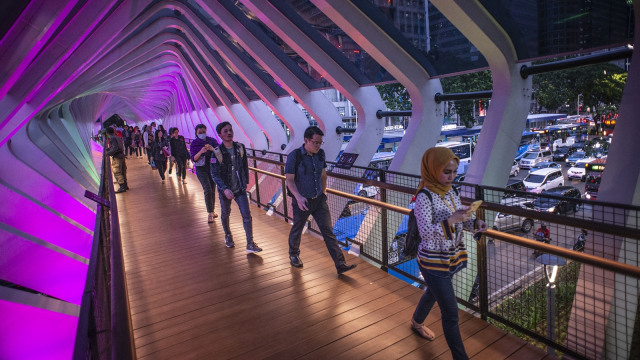 Pejalan kaki melintas di Jembatan Penyeberangan Orang (JPO) Gelora Bung Karno, Senayan, Jakarta, Kamis (28/2). Foto: ANTARA FOTO/Aprillio Akbar