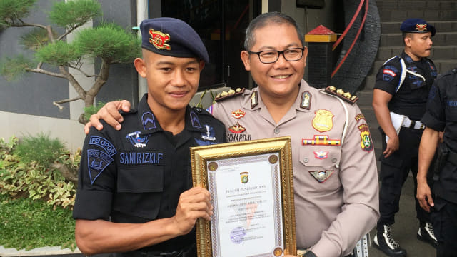Sani Riski menerima piagam penghargaan dari kepolisian. Foto: Sandy Firdaus/kumparan