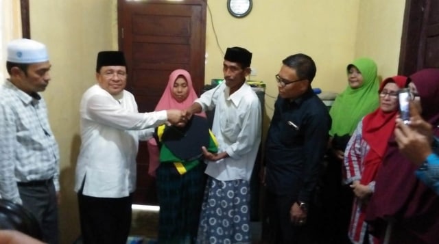 Rektor UIN Ar-Raniry, Prof Warul Walidin (kedua kiri) memberikan Toga untuk keluarga Almarhumah Rina sebagai kenang-kenangan, Kamis (28/2). Foto: Husaini Ende/acehkini